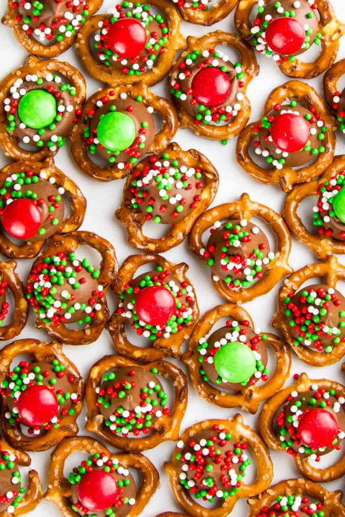 a closeup of christmas m&m pretzel hugs with sprinkles