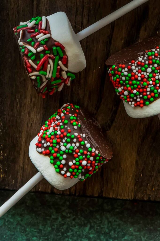 No-Bake Marshmallow Pops – Quick, Fun & Kid-Friendly Overhead view of marshmallow pops with assorted sprinkles in red, green, and white hues