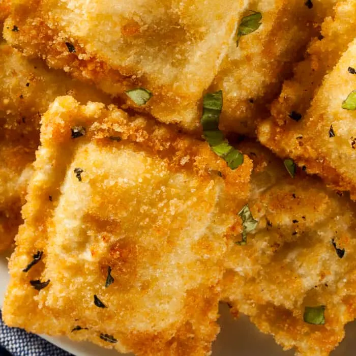 a closeup of fried ravioli sprinkled with chopped parsley