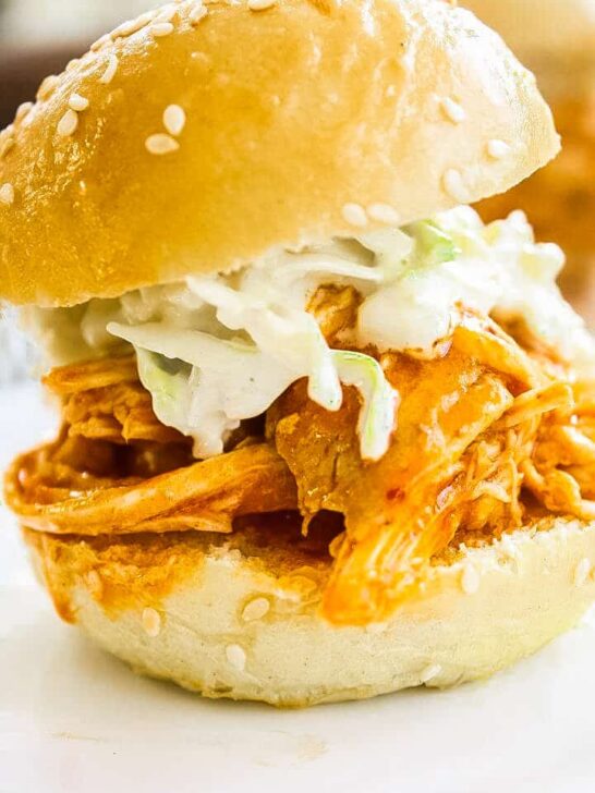 Buffalo Chicken Sliders topped with Blue Cheese Celery Slaw on a white plate