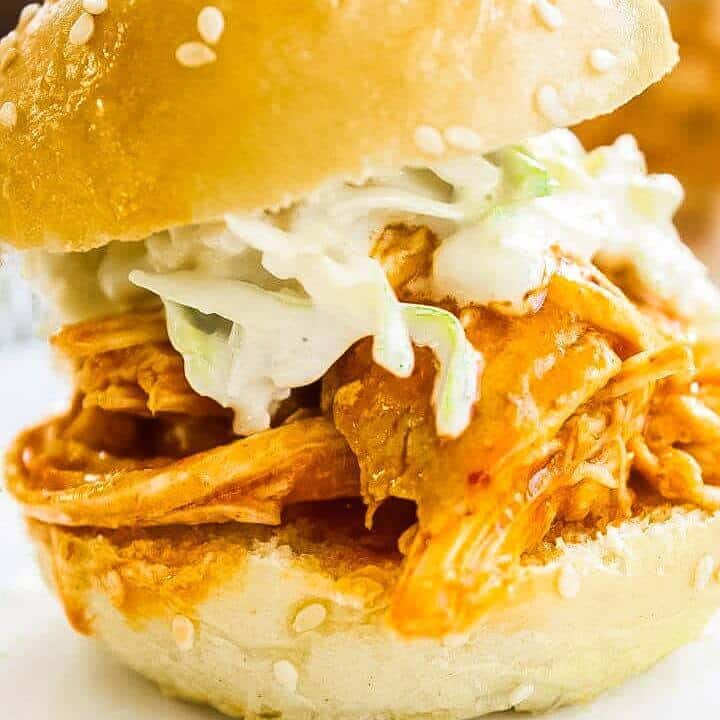 Buffalo Chicken Sliders topped with Blue Cheese Celery Slaw on a white plate