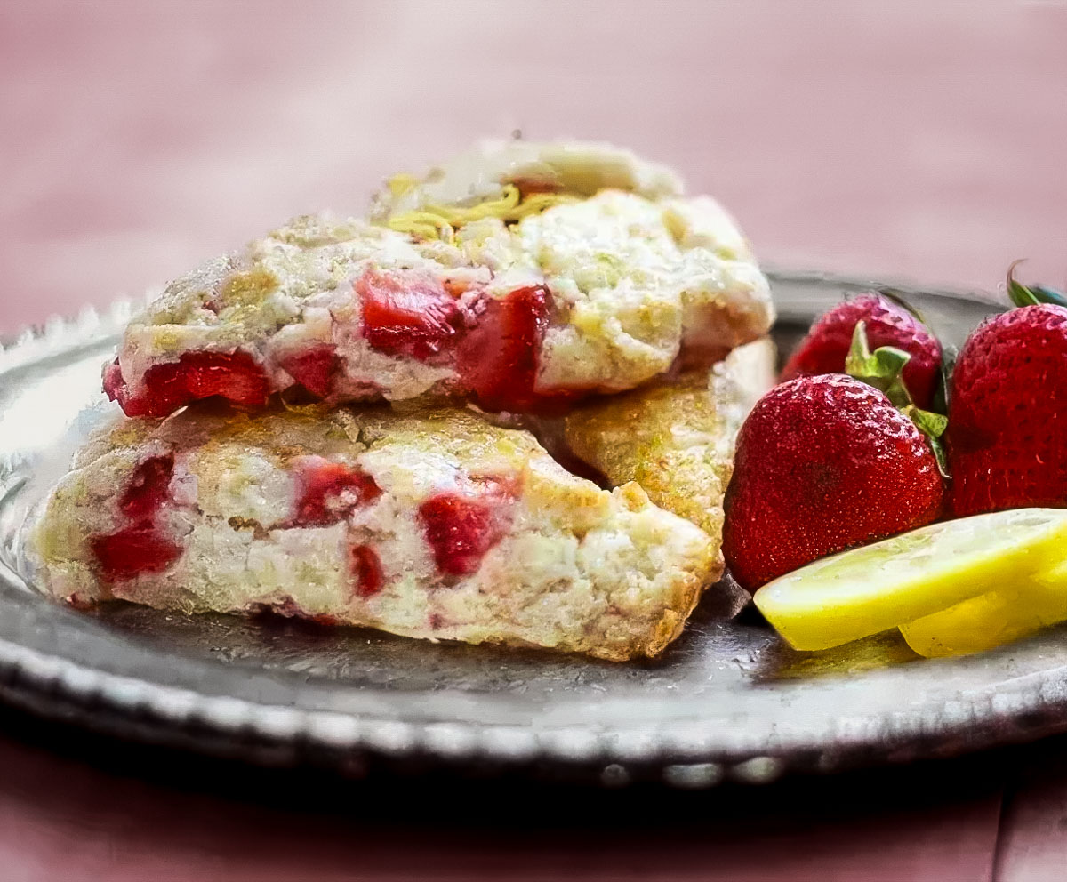 Strawberry Lemon Scones a vintage plate holds three strawberry lemon scones and a few fresh strawberries and lemon slices