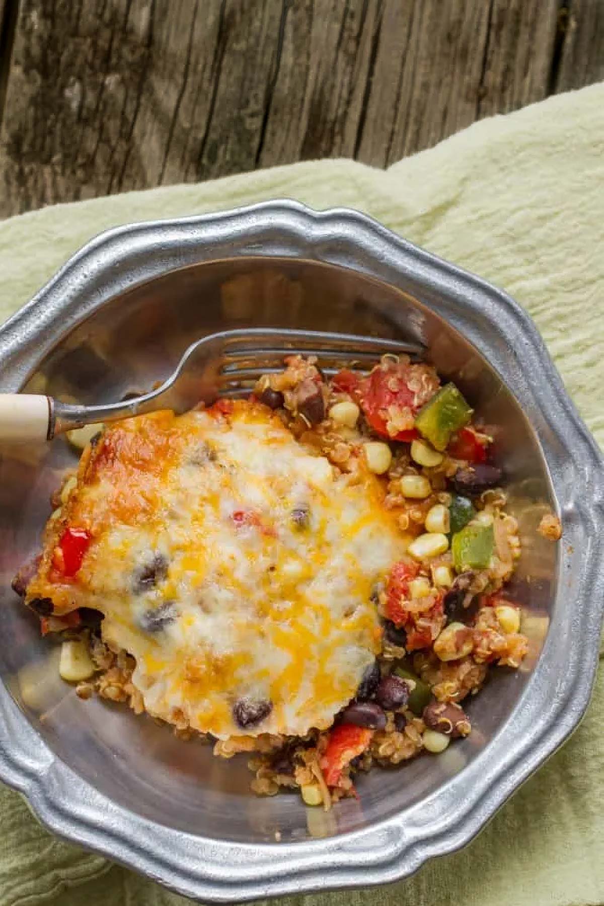 Healthy Mexican Quinoa Casserole a serving of Mexican quinoa casserole in a vintage pewter bowl on a green linen towel