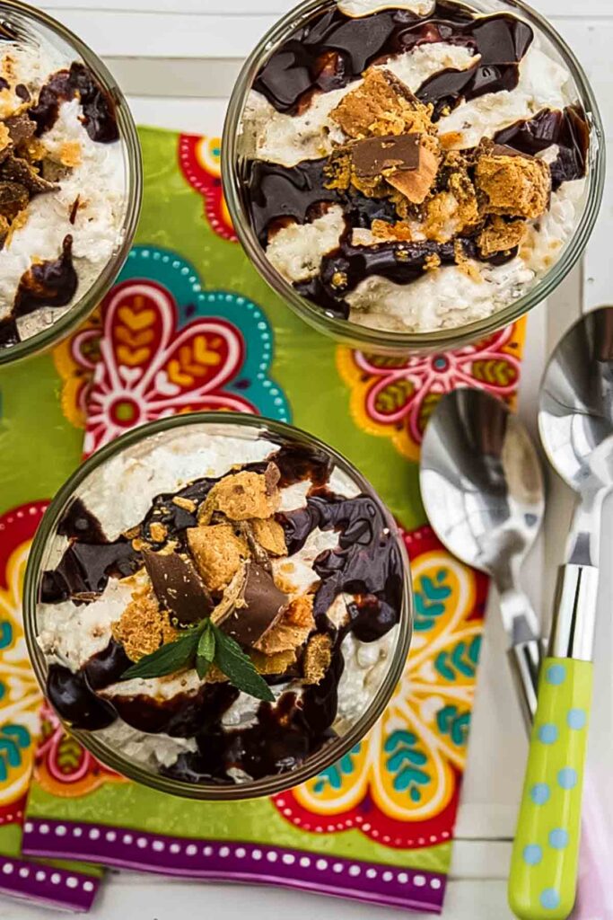 The Best No Bake Butterfinger Pie – Just 10 Minutes Prep! three servings of no bake butterfinger pie on a colorful napkin with a spoon