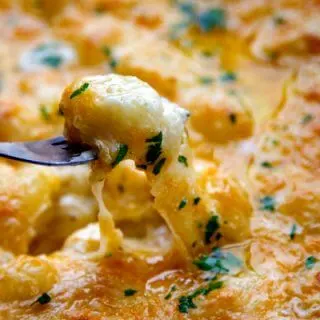 This Cheesy Baked Potato Gnocchi Recipe is easy to make and has a ton of hot, cheesy flavor. A great weeknight meal recipe!