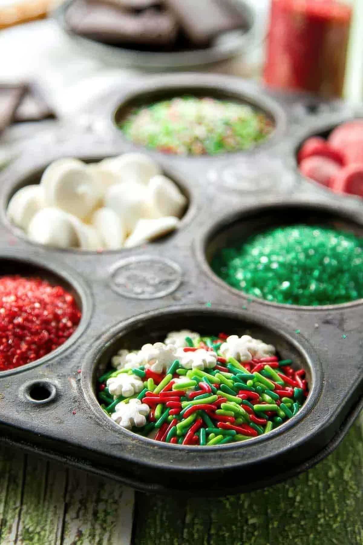 a vintage muffin tin filled with different sprinkles to decorate pretzel rods that have been covered in chocolate