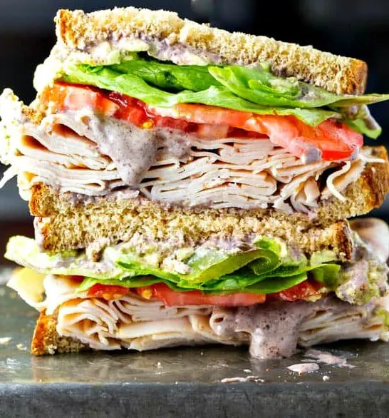 A healthy turkey sandwich recipe! Piled high with turkey, lettuce, tomato, roasted anaheim peppers and a creamy black bean spread!