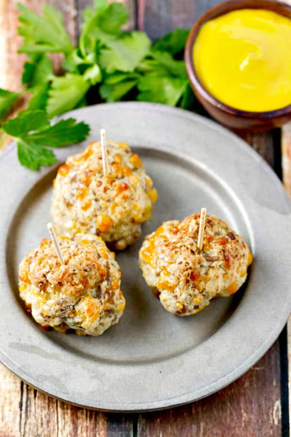 These super easy Bisquick Sausage Balls have just four ingredients, loads of sausage flavor and a cream cheese makes them moist and delish! Serve with mustard, your favorite dipping sauce or just on their own.