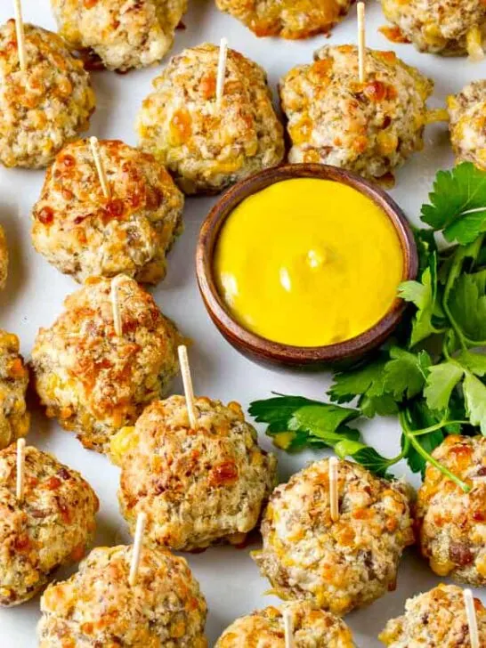 These super easy Bisquick Sausage Balls have just four ingredients, loads of sausage flavor and a cream cheese makes them moist and delish! Serve with mustard, your favorite dipping sauce or just on their own.