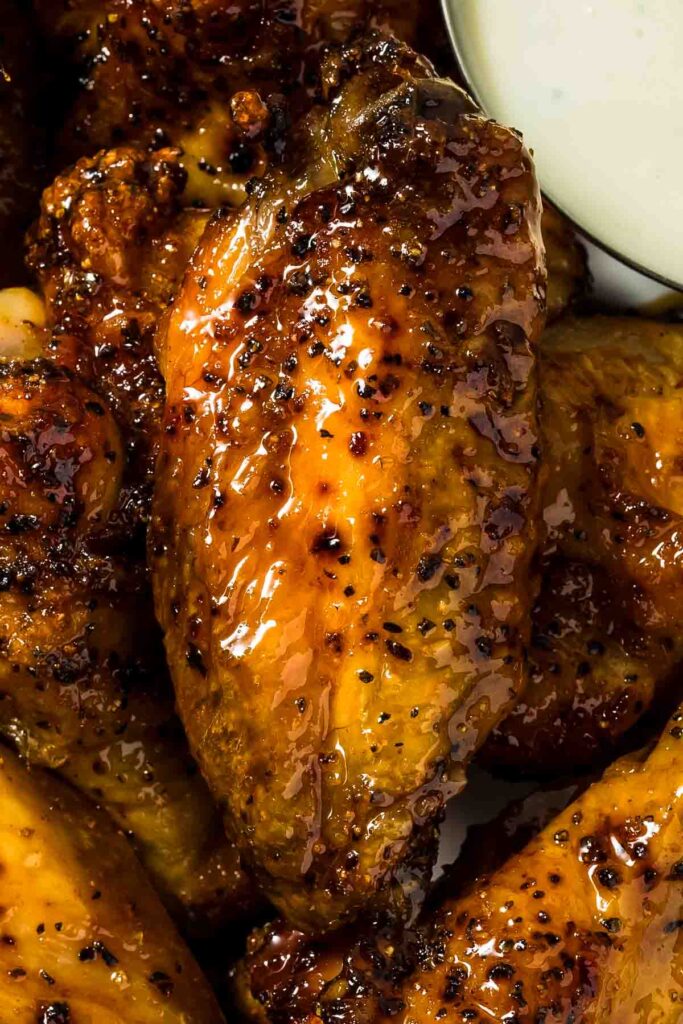 a closeup of a hot honey chicken wing just out of the oven
