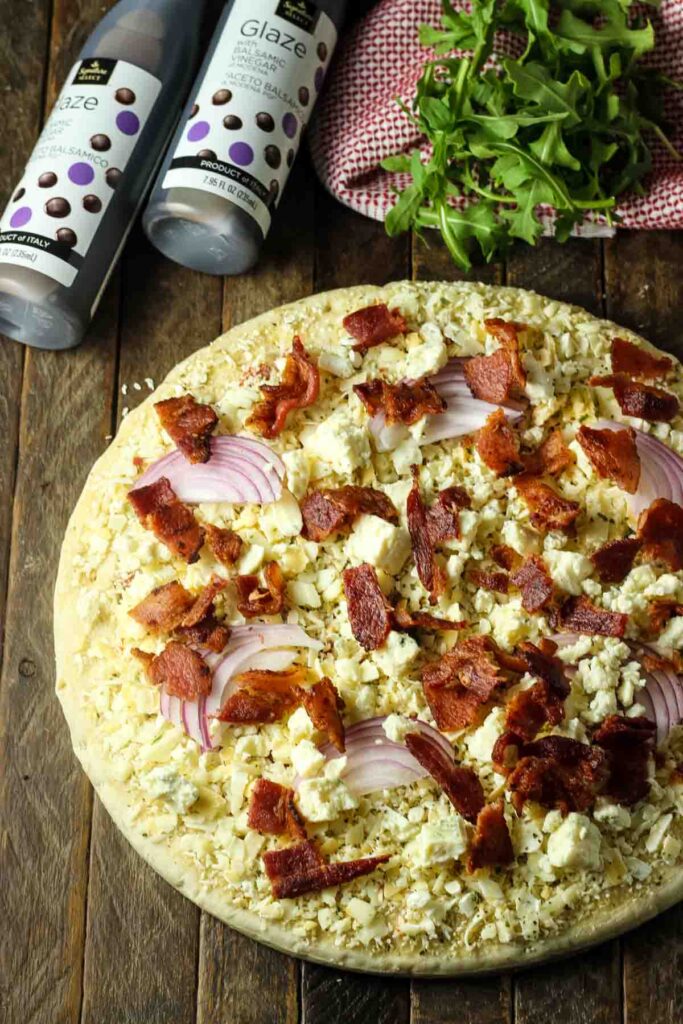Blue Cheese Pizza Recipe – Quick Weeknight Dinner Idea Step 1: Add crumbled blue cheese, sliced red onion, and crispy cooked bacon to the pizza
