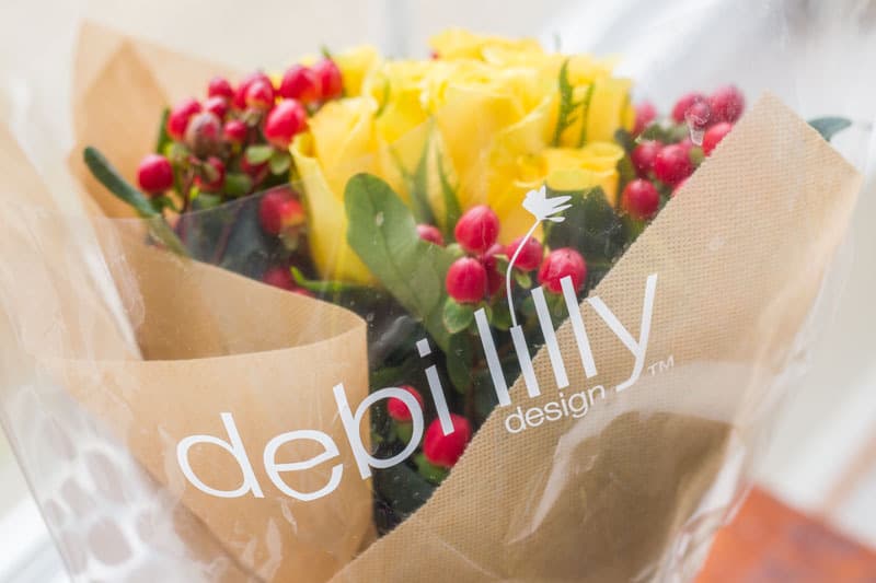 debi lilly floral bouquet with yellow roses and red berries