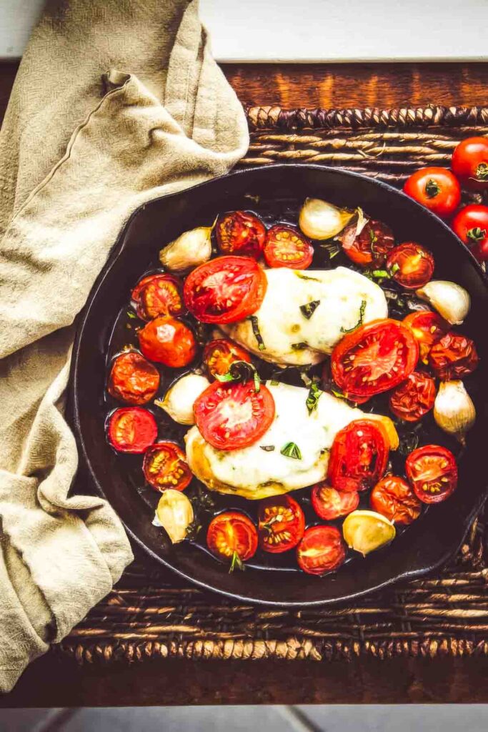 tomato basil chicken fresh out of the oven next to a tan cloth towel