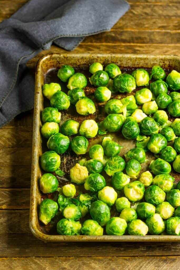 Uncooked Smashed brussels sprouts on a sheet pan ready for the oven