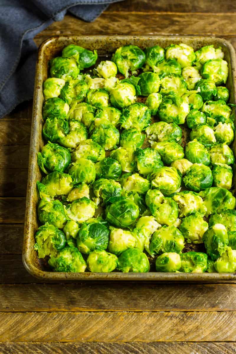 Smashed brussels sprouts on a sheet pan ready for the oven
