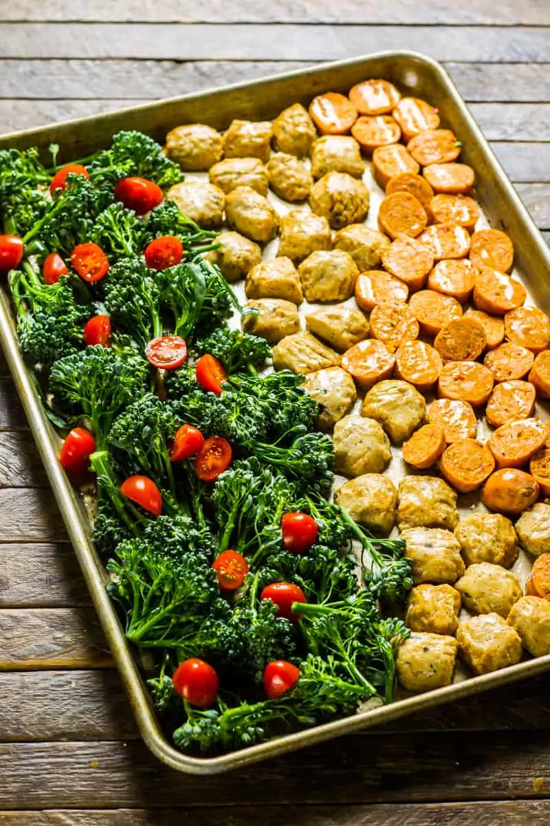 Sausage & Parmesan Broccoli Rabe Sheet Pan Dinner on a wooden table with a rustic napkin.