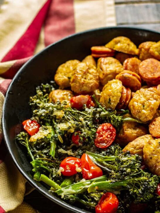 Sausage & Parmesan Broccoli Rabe Sheet Pan Dinner on a wooden table with a rustic napkin.
