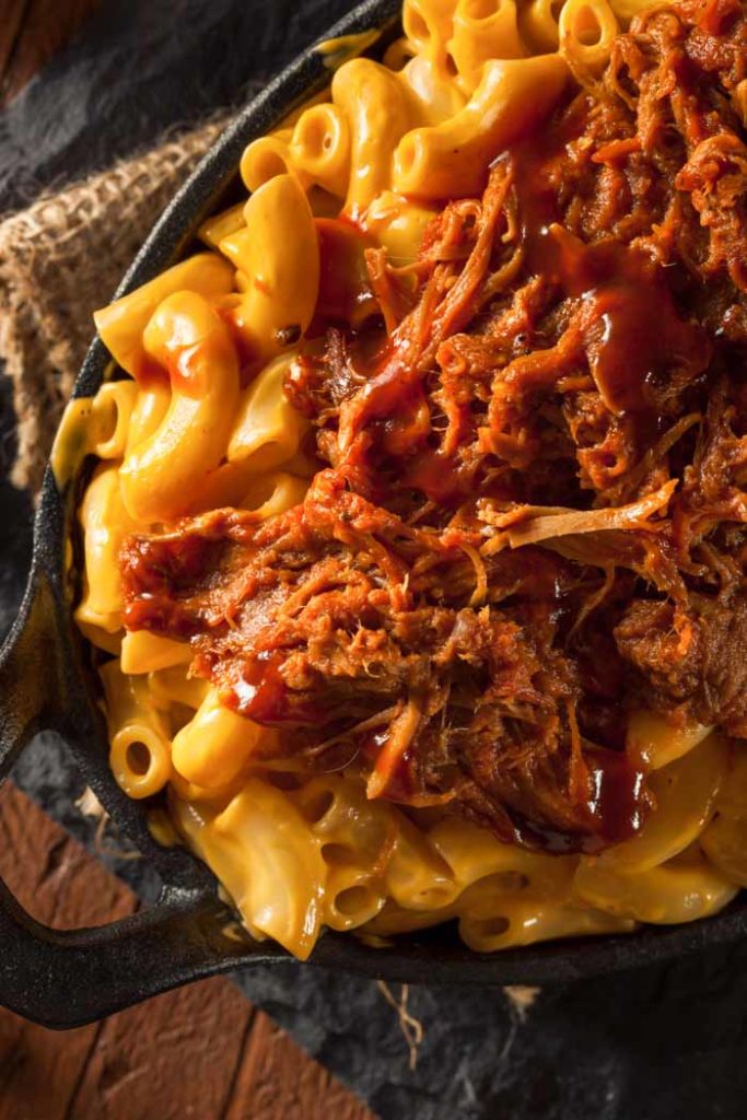 Pulled pork mac and cheese in an oval cast iron skillet 
