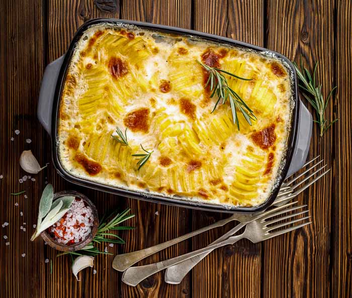 Instant Pot scalloped potatoes on a wood table with three forks