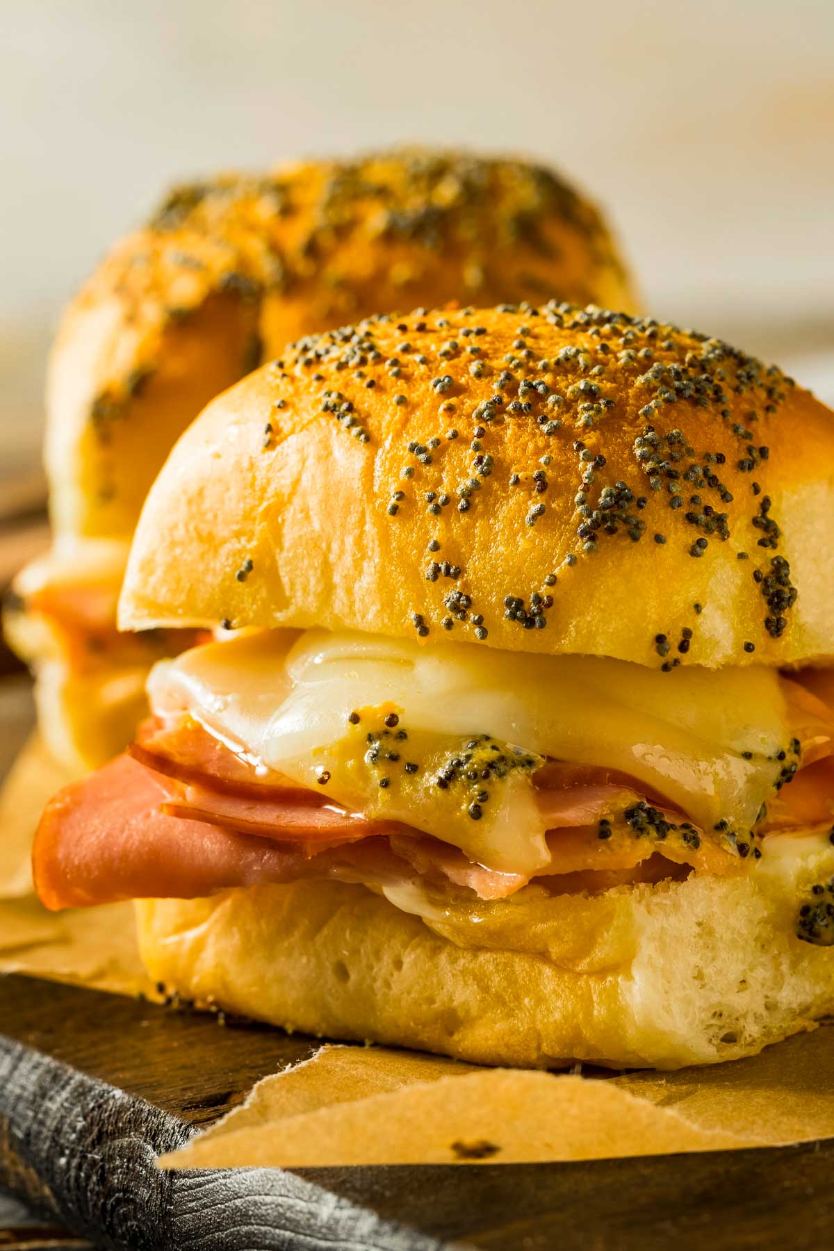 a side view closeup of a hawaiian roll ham and cheese sliders just out of the oven
