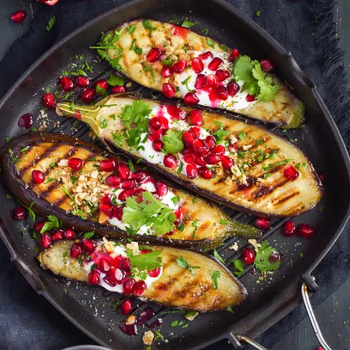 grilled eggplant topped with garlic yogurt sauce, walnuts, pomegranate, and chopped cilantro