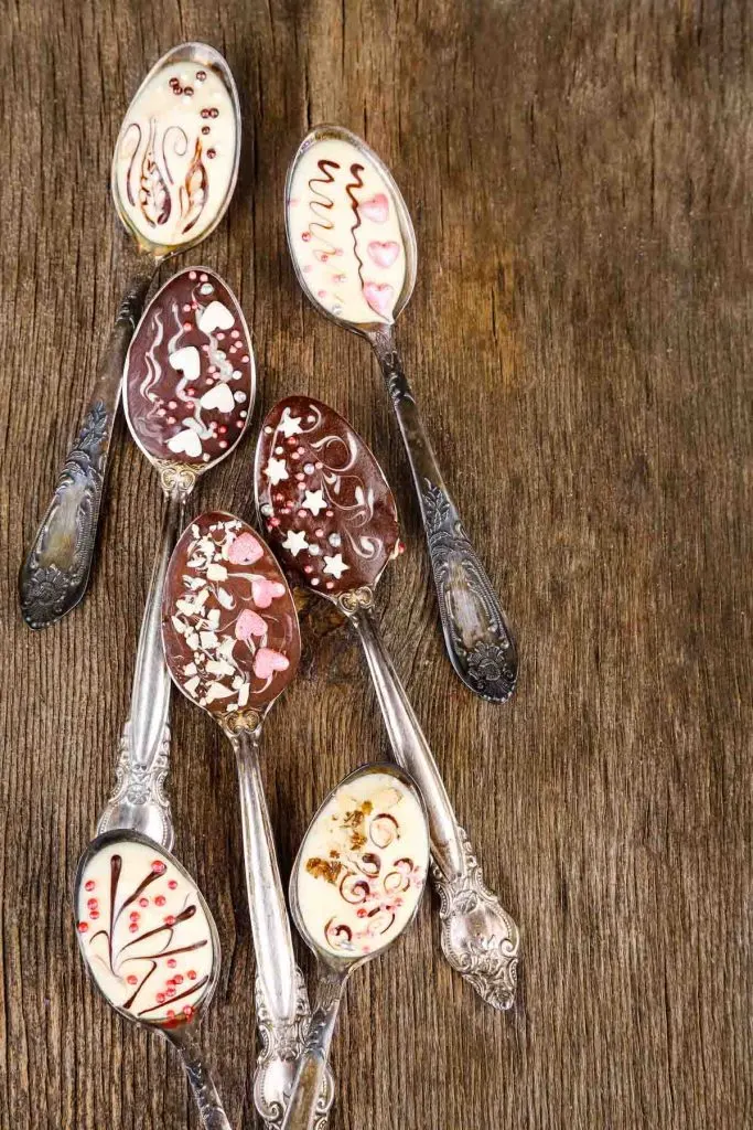 chocolate covered spoons on a wooden table