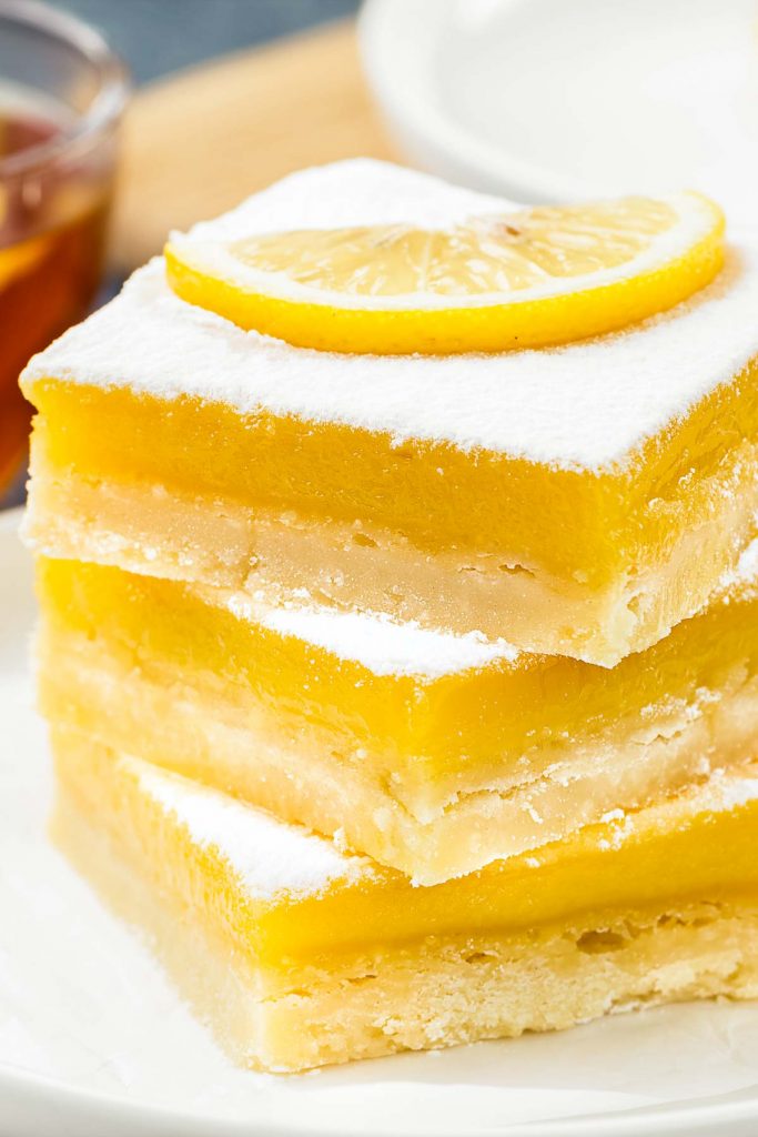 a closeup of a stack of three lemon bars