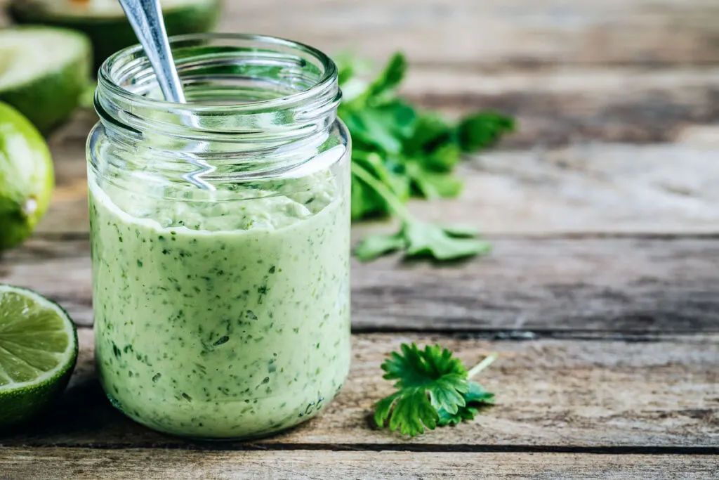 a jar of copycat avocado lime ranch dressing with a spoon