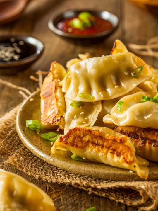 A Plate Of Air Fryer Potstickers On A Wooden Table