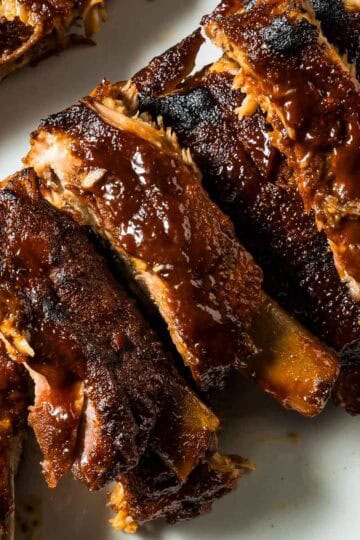 a closeup of st louis style oven-baked ribs just out of the oven on a white plate
