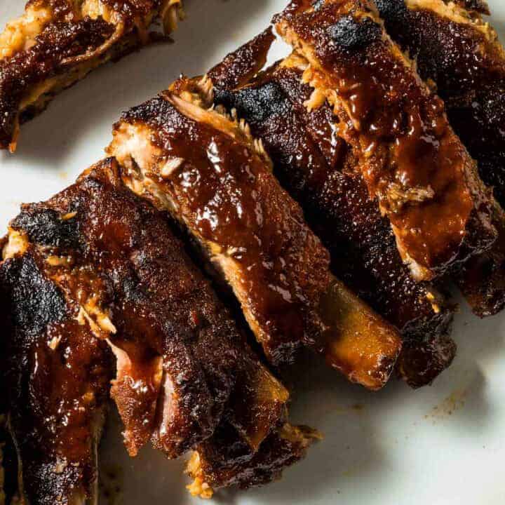 a closeup of st louis style oven-baked ribs just out of the oven on a white plate