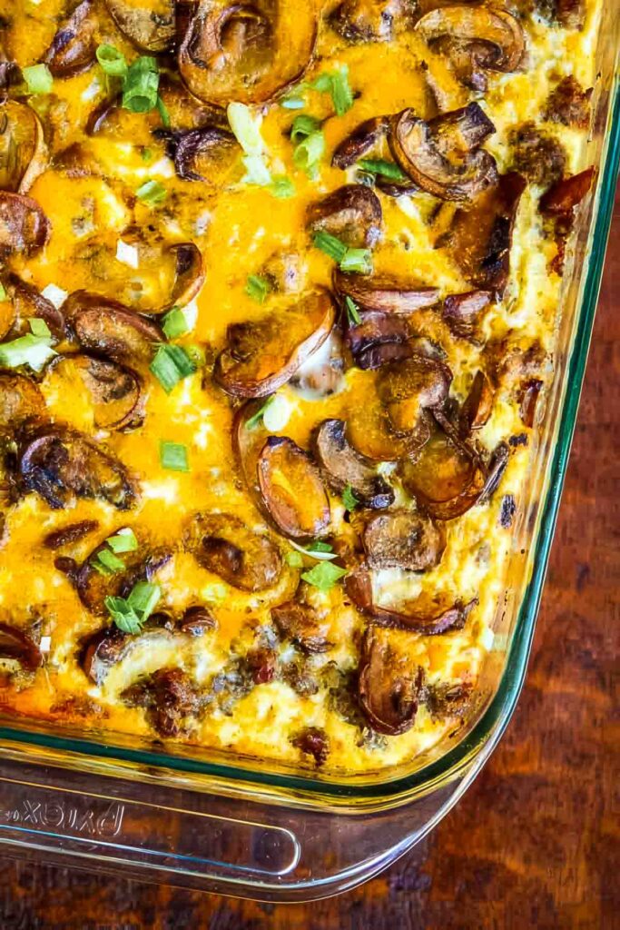 Cheesy Sausage Hash Brown Breakfast Casserole a top-down view of a sausage hash brown breakfast casserole in a glass baking dish and garnished with chopped green onions