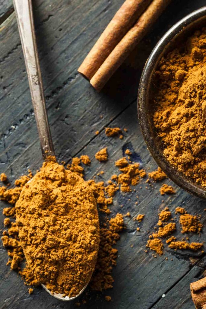 The Best Vanilla Extract Substitutes for Baking and Cooking a closeup of cinnamon sticks and a small dish of ground cinnamon next to a spoonful of ground cinnamon as a vanilla extract substitute