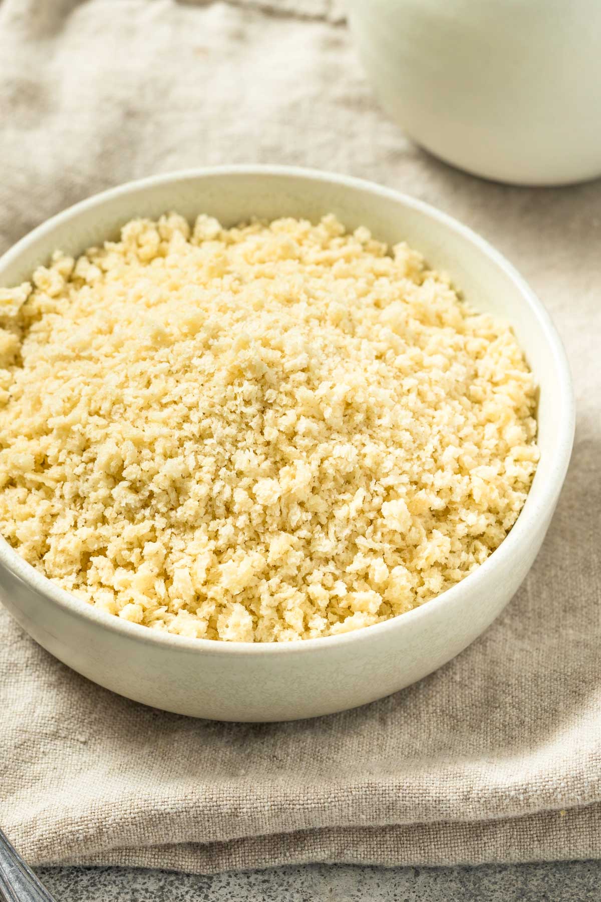 Homemade Panko Breadcrumbs a small bowl of homemade panko breadcrumbs on a tan linen napkin