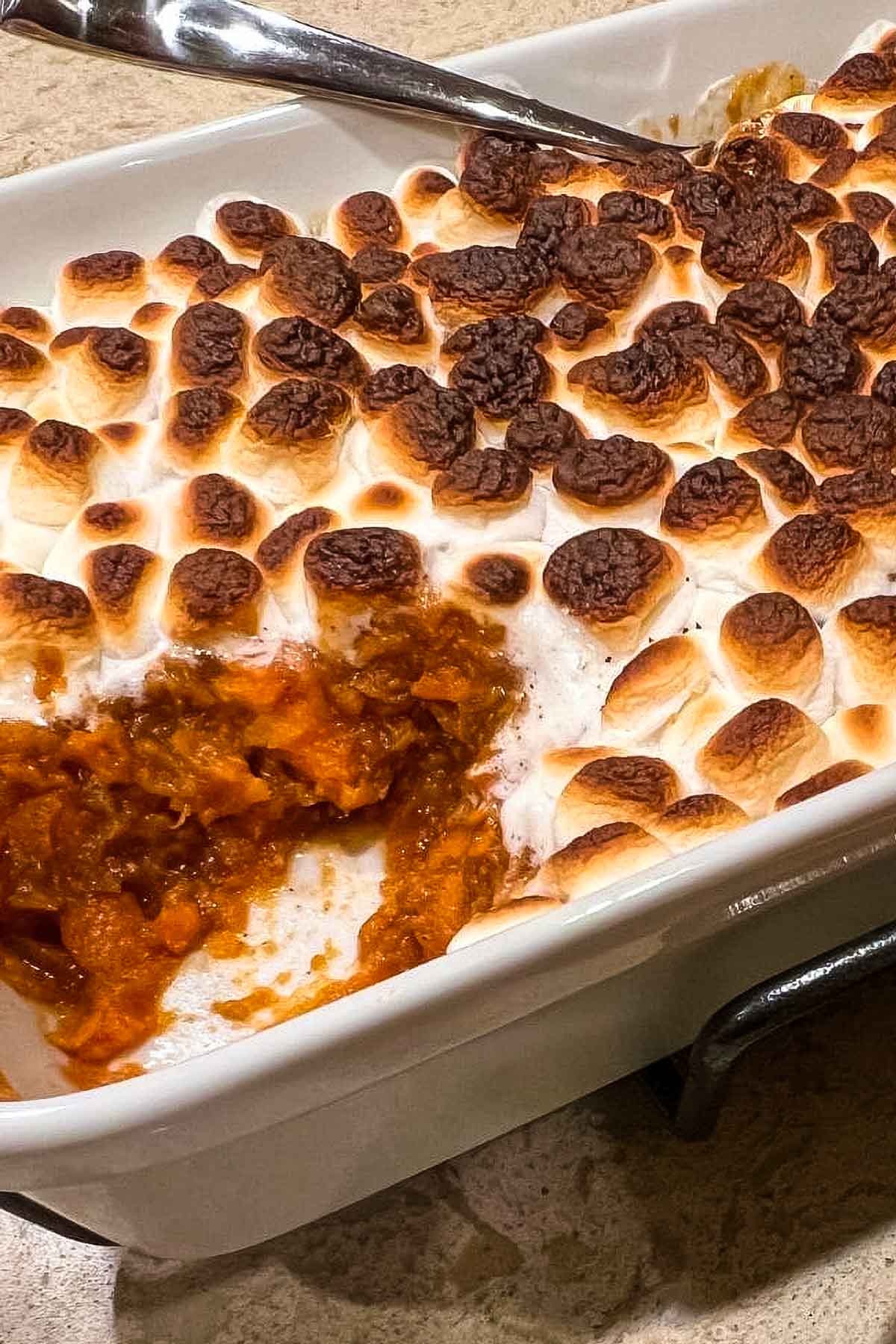 Candied Yams With Marshmallows a closeup of candied yams with marshmallows in a white baking dish