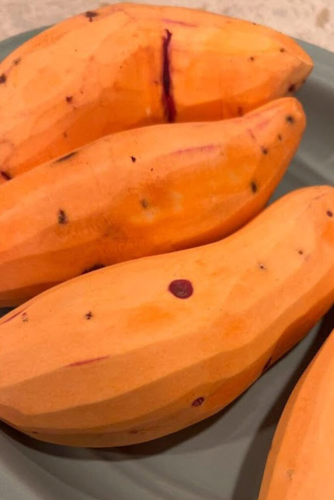 Candied Yams With Marshmallows just-peeled sweet potatoes on a blue plate