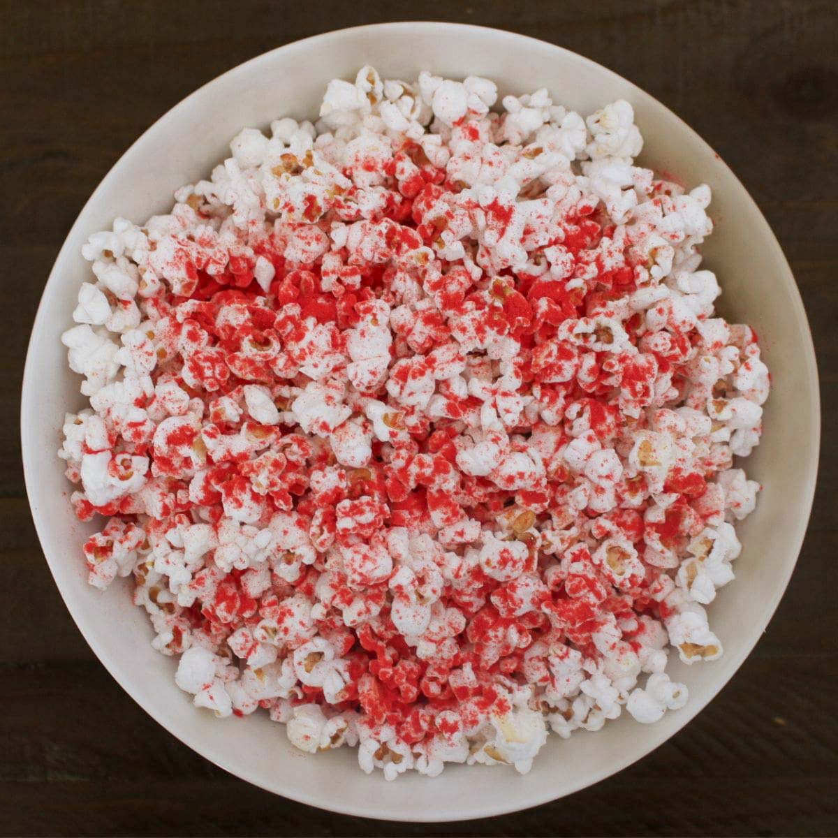 a white bowl filled with popcorn and tossed with flamin hot cheetos seasoning copycat