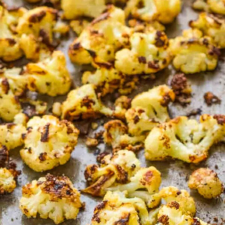 Golden brown parmesan roasted cauliflower on a baking sheet, showing crispy, caramelized edges.