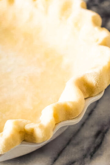 a homemade pie crust just out of the oven on a marble countertop