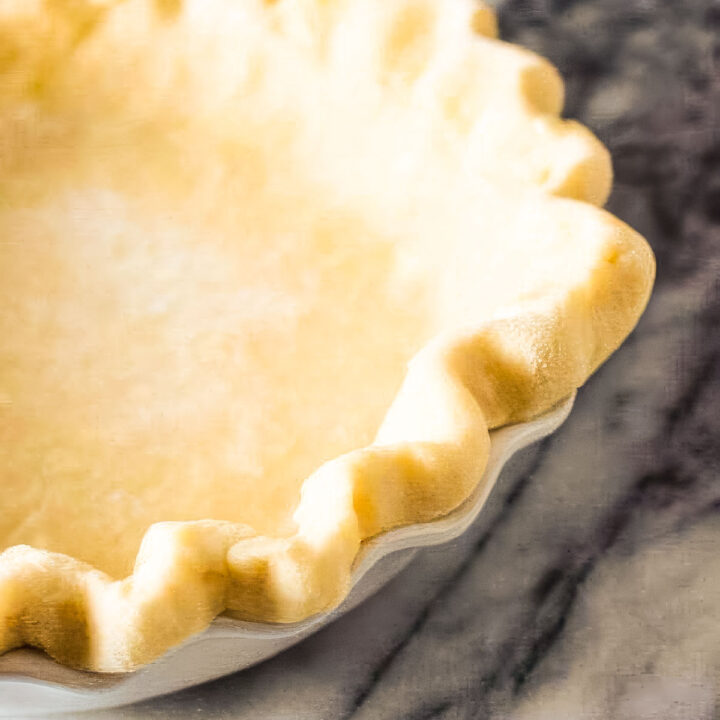 a homemade pie crust just out of the oven on a marble countertop