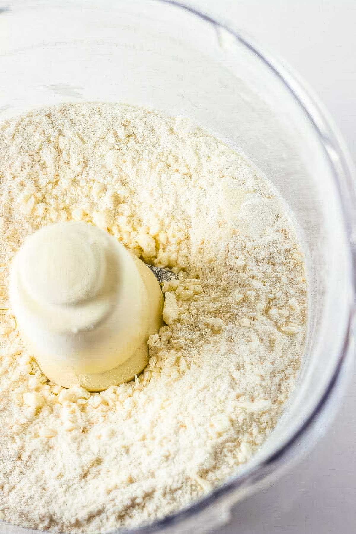 step one of making a homemade pie crust: a food processor with flour, sugar, and salt that's been blended