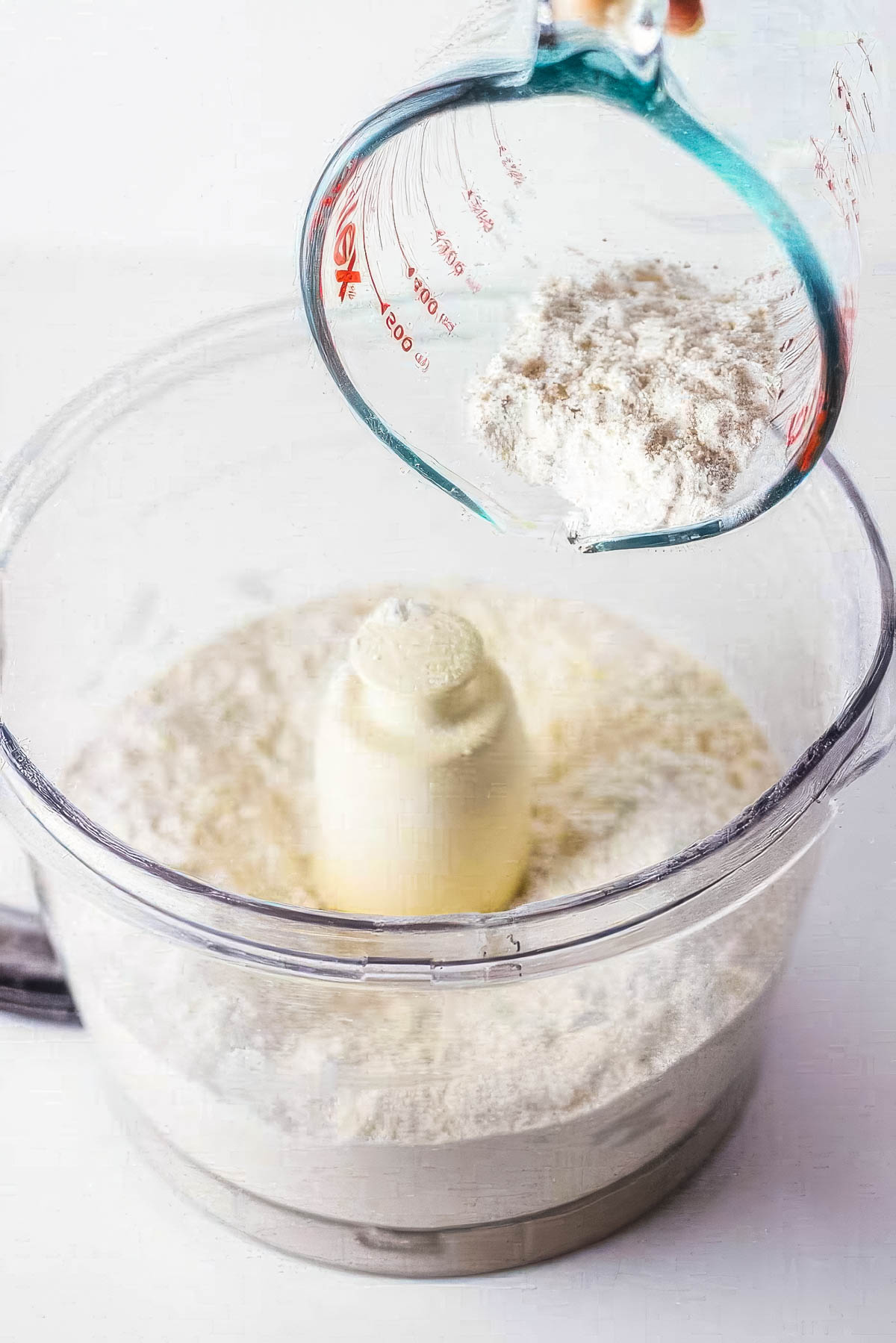 Step three of making a homemade pie crust: Adding the rest of the flour to the food processor.