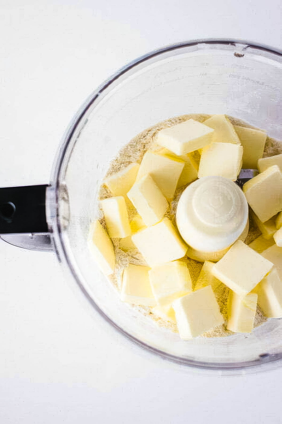 step two of making a homemade pie crust: adding cold butter to the food processor