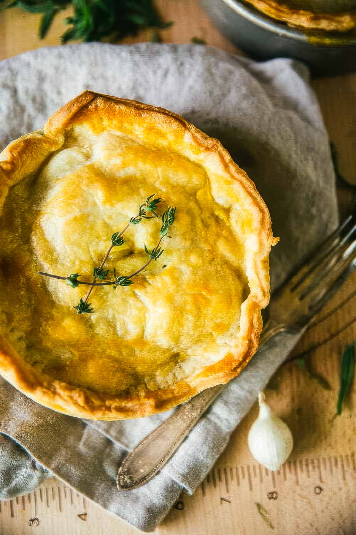 Hearty Veggie Pot Pie (Easy Comfort Food!) a homemade veggie pot pie just out of the oven with a golden brown crust and garnished with fresh thyme sprigs