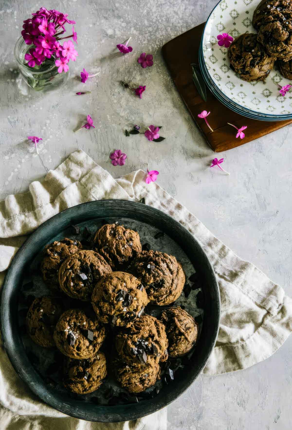 an overhead shot of a vintage plate filled with double chocolate cookies topped with sea salt