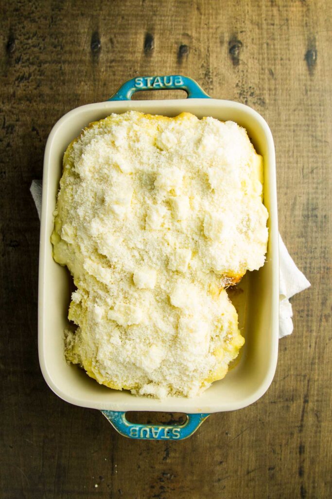 Freezer Shepherd's Pie freezer shepherd's pie halfway through baking, covered with grated parmesan and dots of butter, ready to go back into the oven