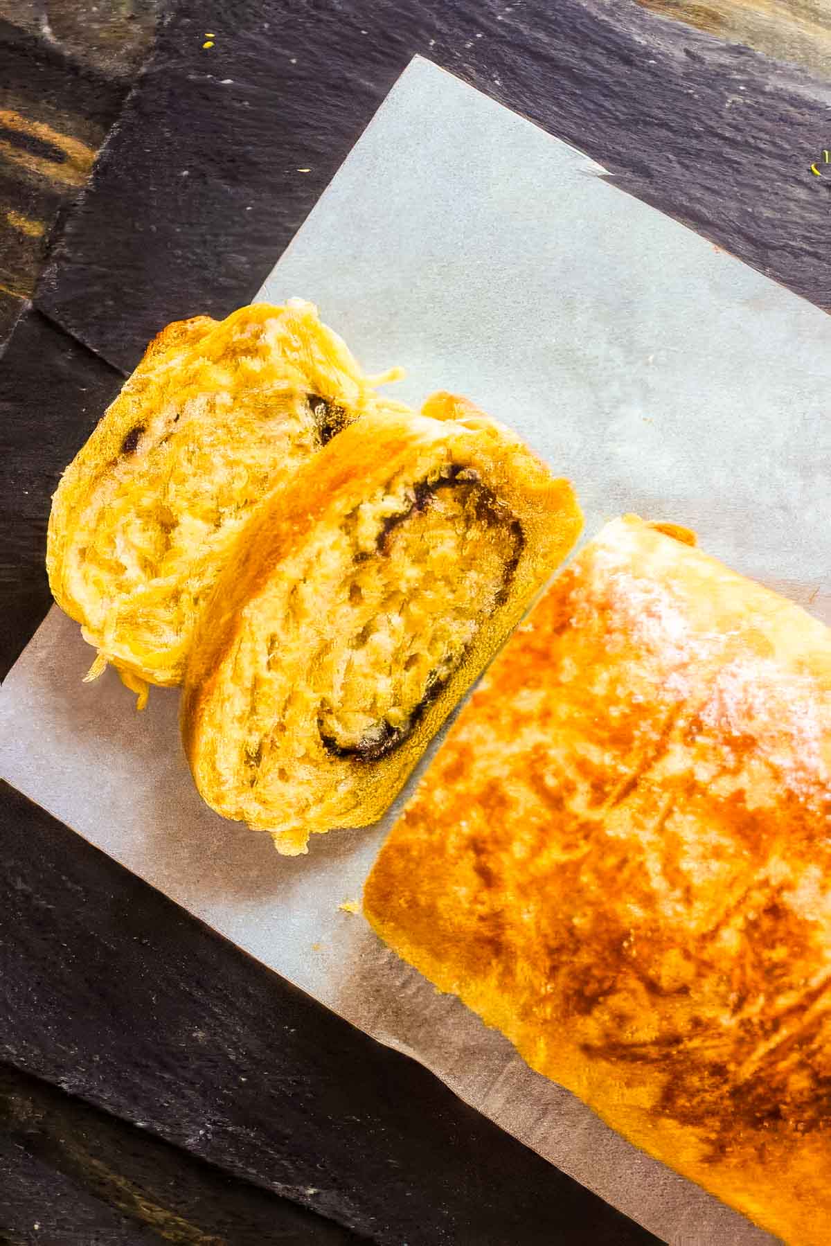 Pumpkin Brioche with Chocolate Swirl a top down view of a loaf of pumpkin brioche on a white cloth napkin with two slices cut out