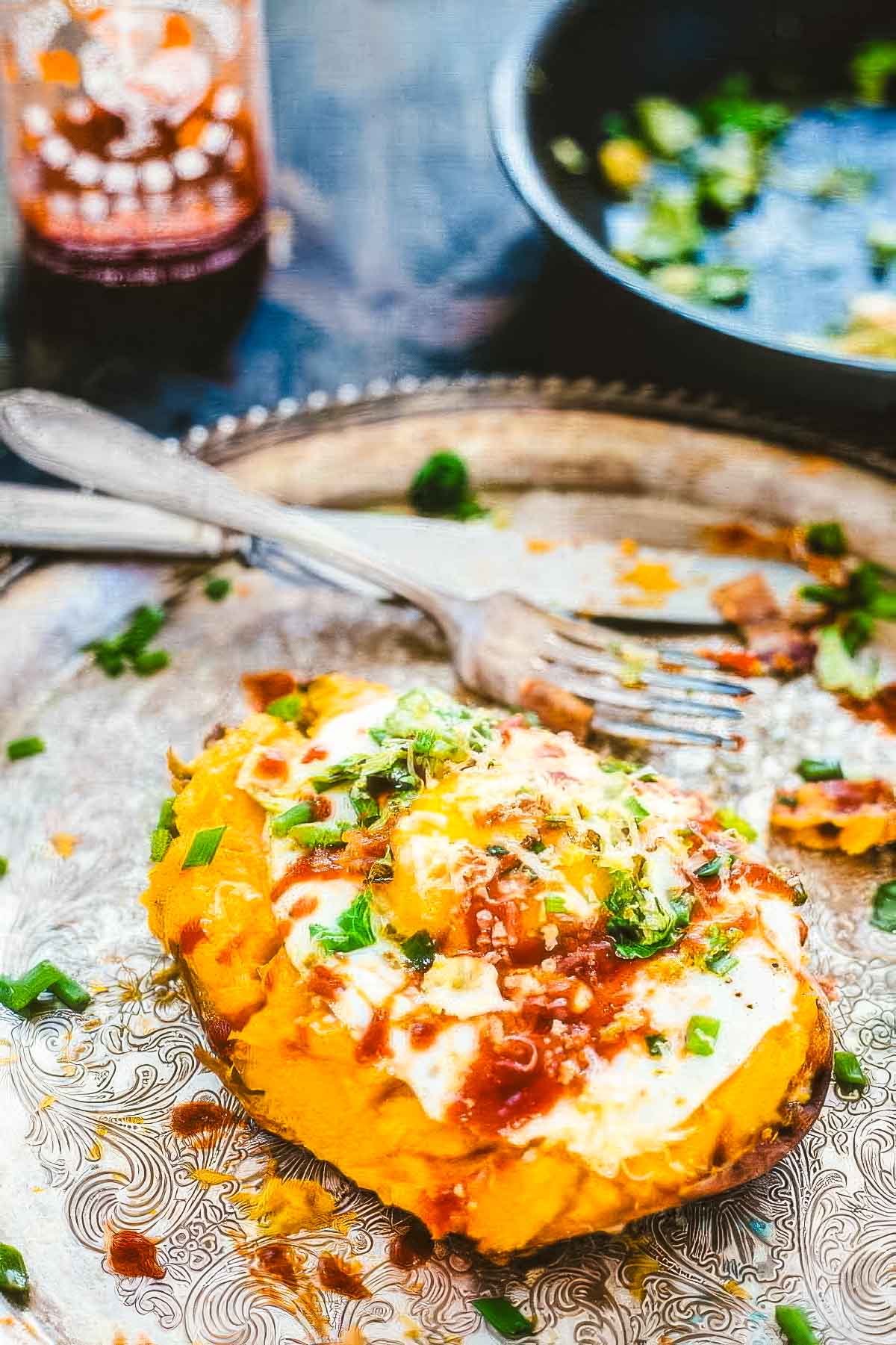 Loaded Twice-Baked Sweet Potatoes a vintage platter of twice baked sweet potatoes with a fork and knife