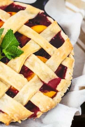 Frozen Berry Pie a frozen berry pie baked in a cast iron skillet just out of the oven on a white kitchen towel