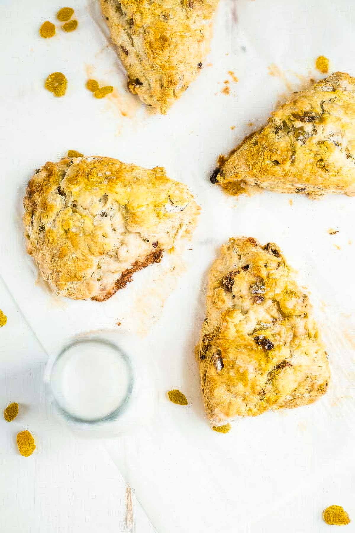 Irish Soda Bread Scones with Cinnamon Honey Butter three irish soda bread scones on parchment paper next to a glass of milk